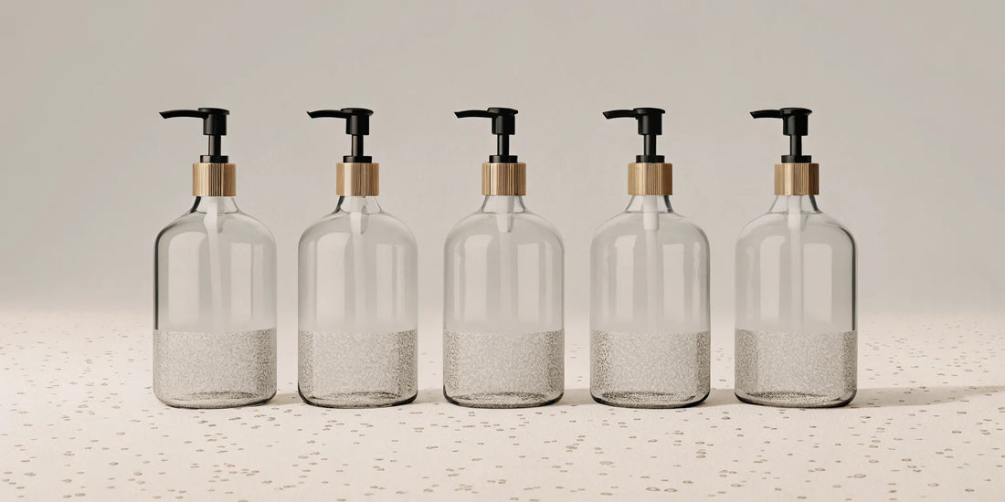 A row of clear pump bottles filled with the best refill hand soap options.