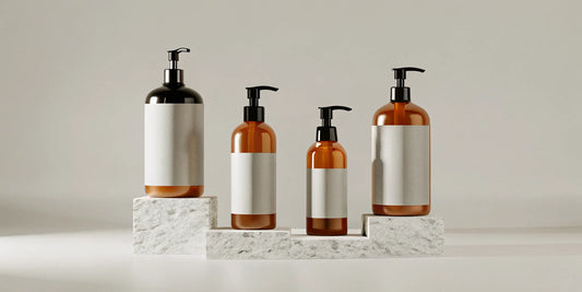 A collection of stylish black pump bottles for soap and lotion on a marble countertop.