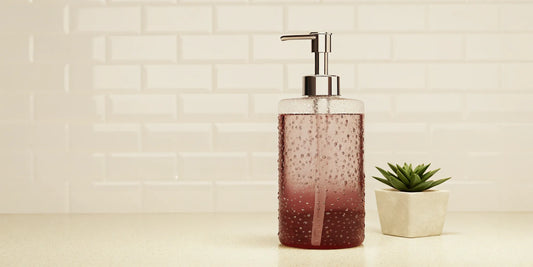 A stylish glass dispenser filled with an Aesop dupe hand soap refill.