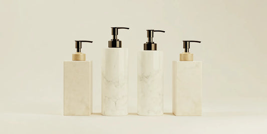 High-end soap dispensers with a marble finish and sleek pump design.