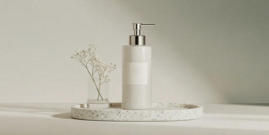 A stylish refillable soap dispenser with a chrome pump on a modern bathroom counter.