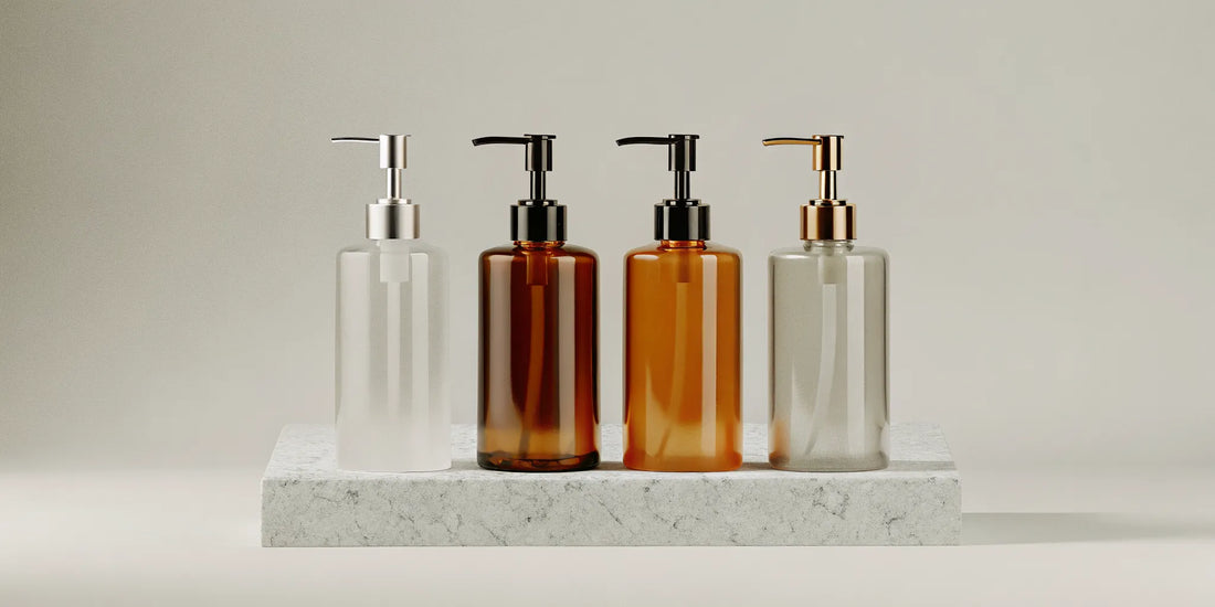 A collection of stylish soap bottles with pumps in clear and amber glass.