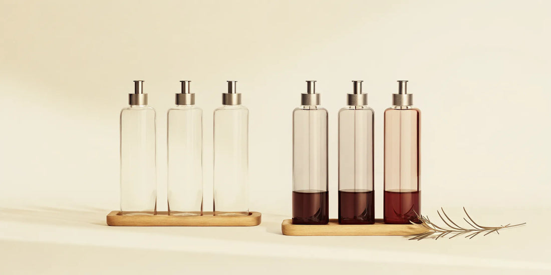 A glass kitchen bottle set with pumps on a wooden tray for an organized countertop.