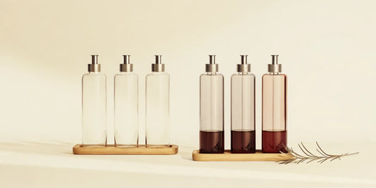 A glass kitchen bottle set with pumps on a wooden tray for an organized countertop.