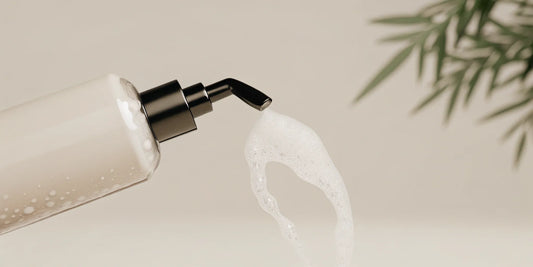 A gentle hand soap refill being poured into a reusable pump dispenser.