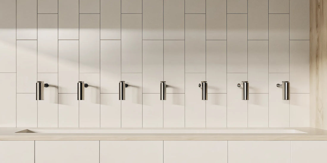 Modern wall mounted kitchen dispensers with a minimalist design on a tiled wall.