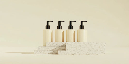 Four minimalist pump soap bottles on stone blocks, an alternative to Aesop Reverence.