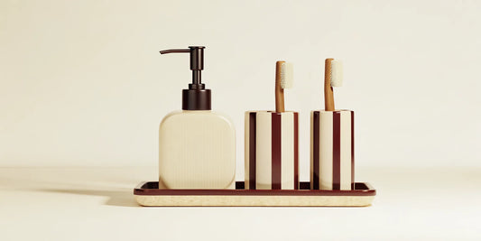 A modern kitchen soap set with a pump dispenser and matching striped holders on a tray.