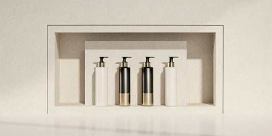 Sleek body wash dispensers organized in a modern, tiled shower niche.