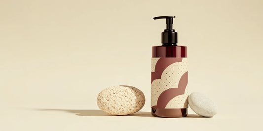 Amber exfoliating hand soap beside fine pumice and stone