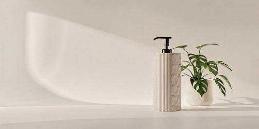 A modern dispenser for hotel hand soap refills on a clean bathroom counter.