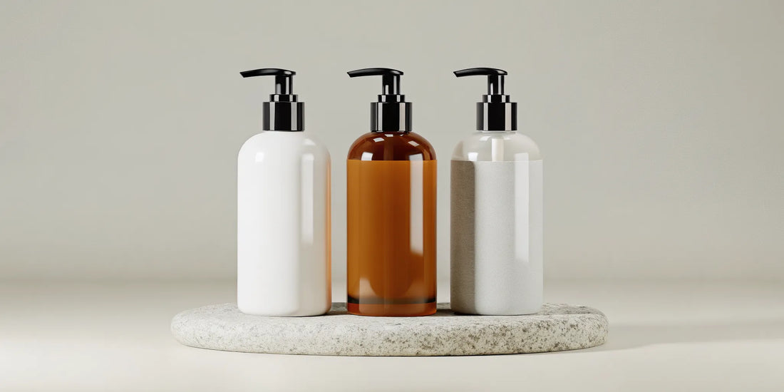 A selection of white and amber lotion bottle dispensers with pumps on a stone tray.