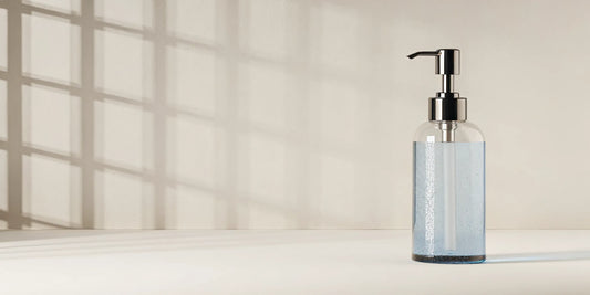 A clear soap dispenser with blue soap, part of a tutorial on how to fix the pump.