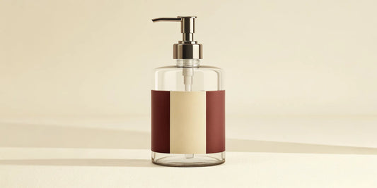 A glass dispenser filled with liquid hand wash from a refill pack.