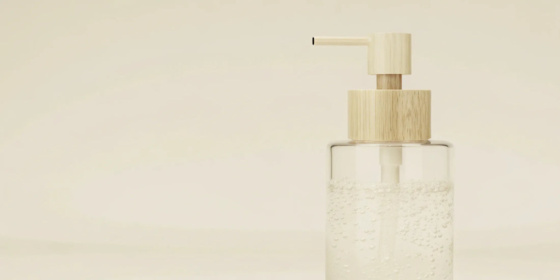 A clear glass soap dispenser with a pump, ready to be refilled with liquid soap.
