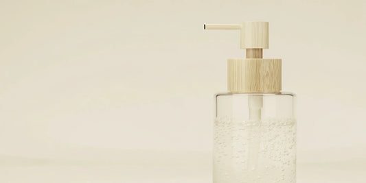 A clear glass soap dispenser with a pump, ready to be refilled with liquid soap.