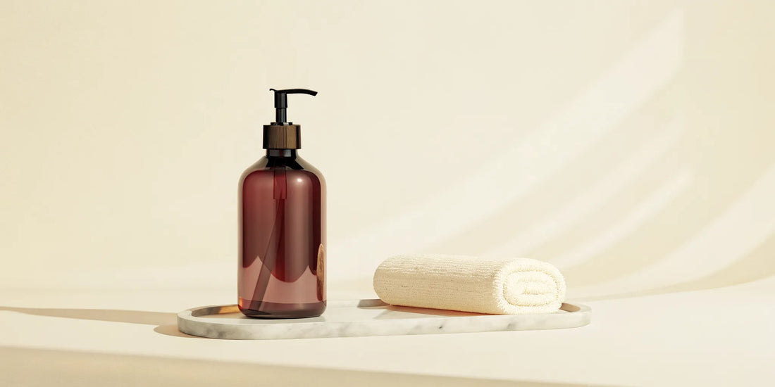 A minimalist, quiet luxury bathroom vanity setup featuring AEP Scent endlessly refillable amber hand soap dispenser
