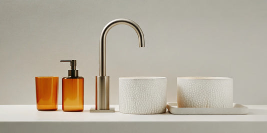 Luxe soap and lotion set in amber glass bottles on a minimalist bathroom sink.