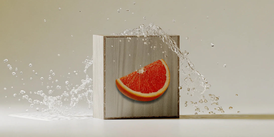 A hand holding a fresh grapefruit slice for a grapefruit hand soap refill.