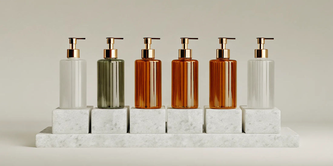 Bottles of the best luxury hand wash with gold pumps arranged on a marble surface.