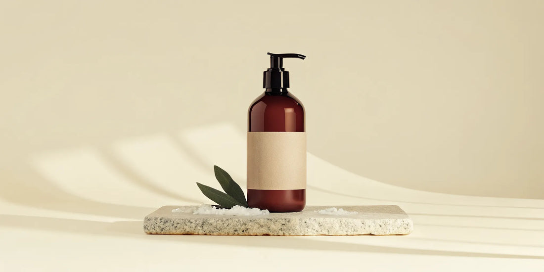 Premium amber pump bottle of Coastal Sage body wash on a stone tray in a luxury bathroom