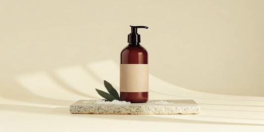 Premium amber pump bottle of Coastal Sage body wash on a stone tray in a luxury bathroom