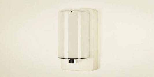 A modern, refillable wall mounted soap dispenser.