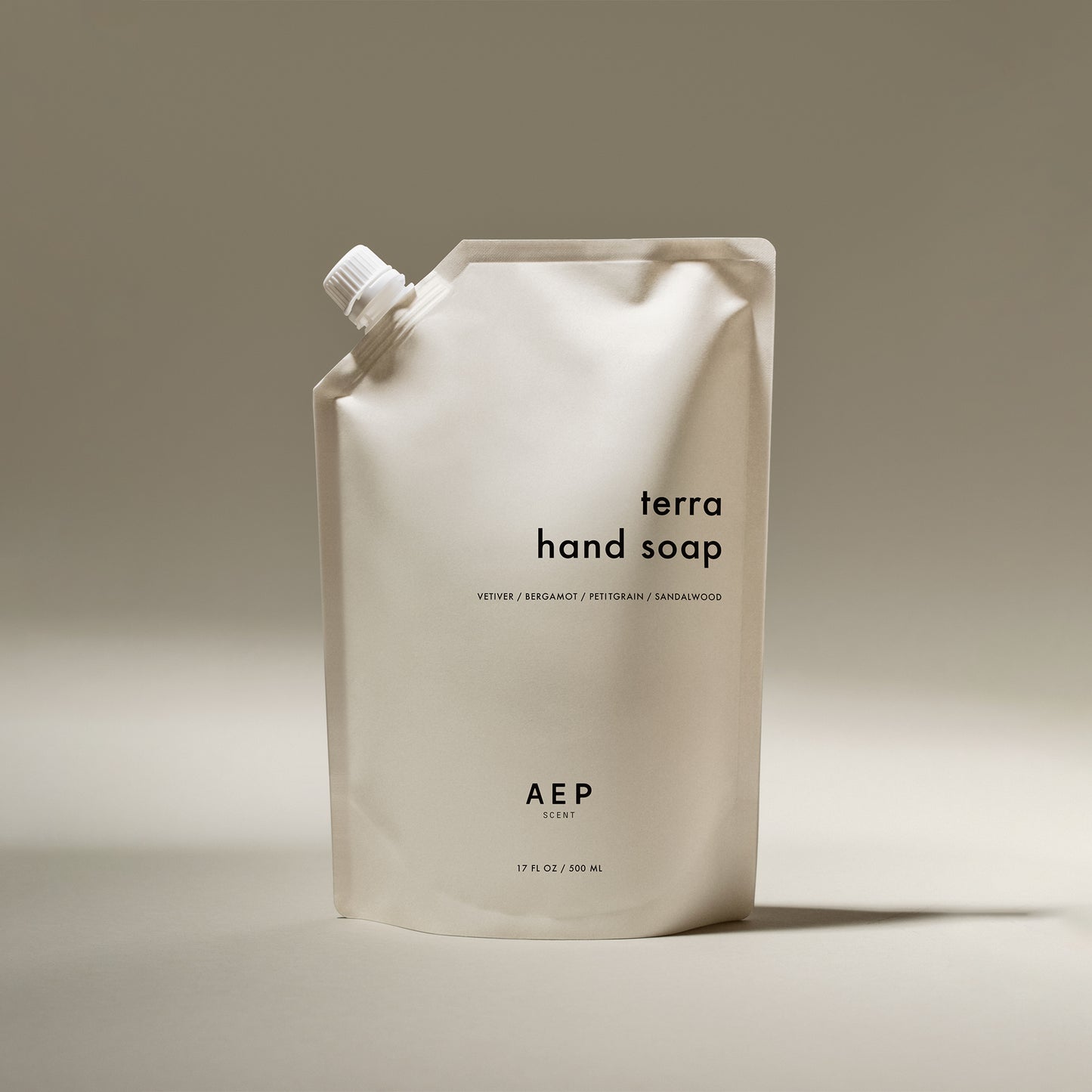 AEP Scent Terra hand soap refill pouch featuring notes of vetiver, bergamot, petitgrain, and sandalwood on a beige background.