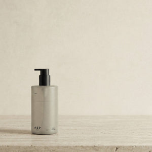 AEP Scent reusable, transluscent soap dispenser bottle in matte beige with black pump, minimalist design for premium refill use, photographed on a neutral background.