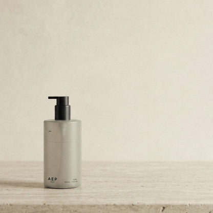 AEP Scent reusable, transluscent soap dispenser bottle in matte beige with black pump, minimalist design for premium refill use, photographed on a neutral background.