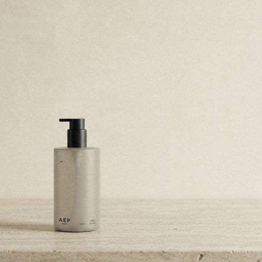 AEP Scent reusable, transluscent soap dispenser bottle in matte beige with black pump, minimalist design for premium refill use, photographed on a neutral background.