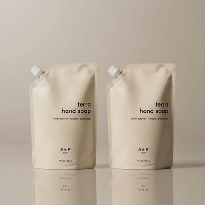 Two AEP Scent Terra hand soap refill pouches on a beige background, featuring notes of vetiver, bergamot, petitgrain, and sandalwood, showcasing the 2-pack value  bundle option.