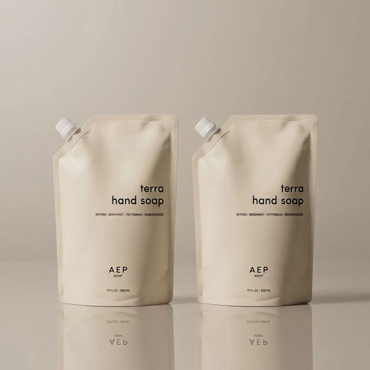 Two AEP Scent Terra hand soap refill pouches on a beige background, featuring notes of vetiver, bergamot, petitgrain, and sandalwood, showcasing the 2-pack value  bundle option.