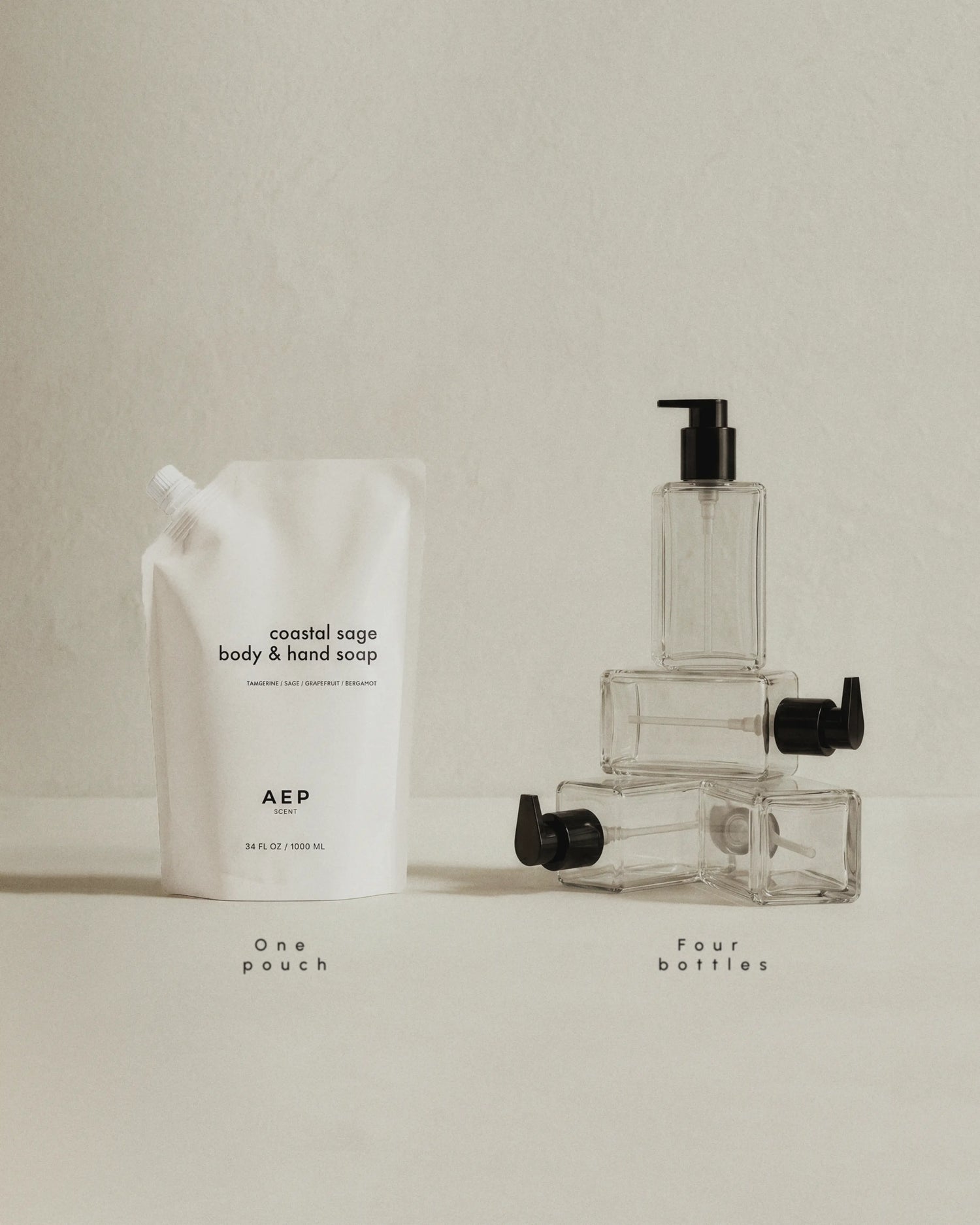 Set of body and hand soap products including a pouch and bottles on a neutral background