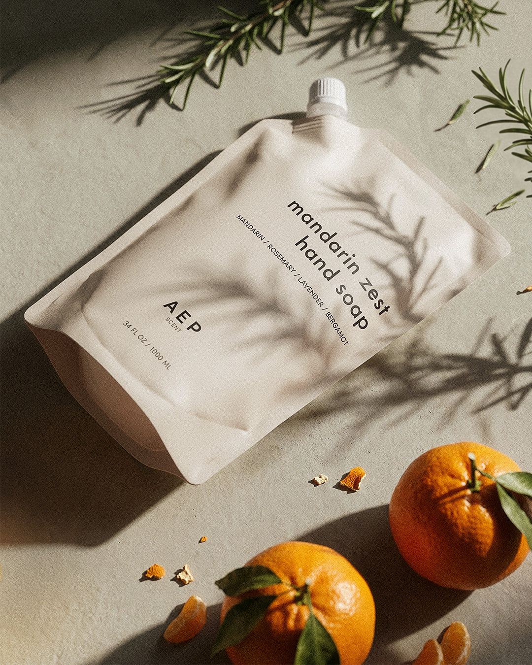 Hand soap packaging with mandarin oranges and leaves on a neutral background